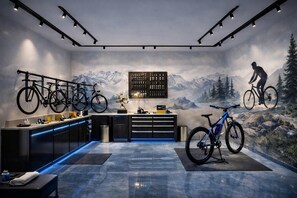 A modern kitchen with a mountain mural, bicycles, and a bar area.