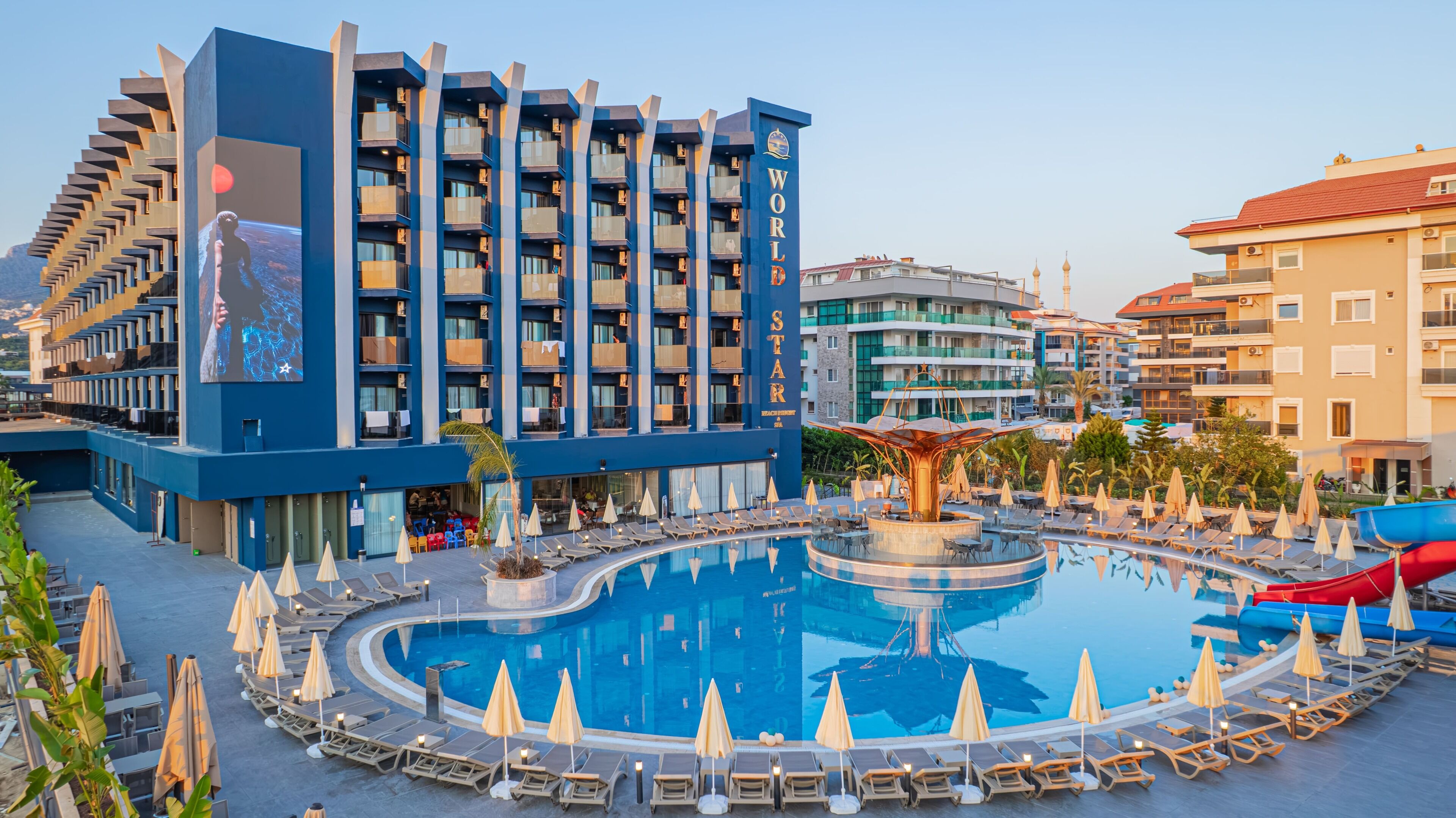 A hotel with a large pool, multiple balconies, and a beachside view.
