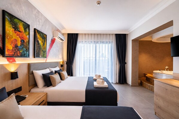 A hotel room with a bed, bedside tables, a desk, a TV, a bathroom with a bathtub, and artwork on the wall. - World Star Beach Resort & Spa (Alanya)
