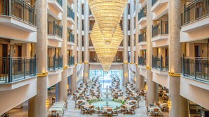 A hotel atrium with multiple floors, a central fountain, and a large chandelier. - World Star Beach Resort & Spa (Alanya)