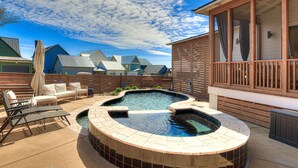 A backyard with a hot tub, outdoor furniture, and a wooden deck. - Luxury Pistache Park Retreat | Private Pool + Hot Tub | Carlton Landing (Carlton Landing)