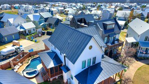 A residential area with houses featuring gabled roofs and a swimming pool. - Luxury Pistache Park Retreat | Private Pool + Hot Tub | Carlton Landing (Carlton Landing)