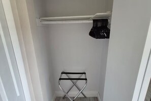Ein kleiner, geschlossener Abstellraum mit einem Wäscheständer aus Metall und einer Ablagefläche.