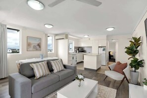 Un salón moderno con sofá, mesa de centro y mesa de comedor.