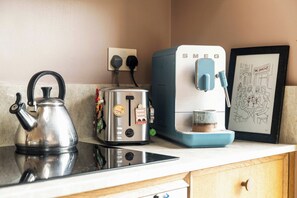 A kitchen with a kettle, toaster, and Smeg coffee machine on the counter. - The Sun Deck Townhouse (Greater London)