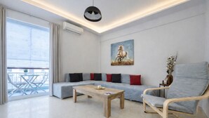 Una sala de estar moderna con un sofá, una mesa de centro de madera, una silla y un cuadro en la pared.