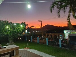 Um pátio com mesa, cadeiras, uma árvore e um cercado.
