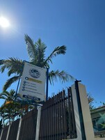 Placa indicando comodidades como café, acesso à internet, televisão e estacionamento.