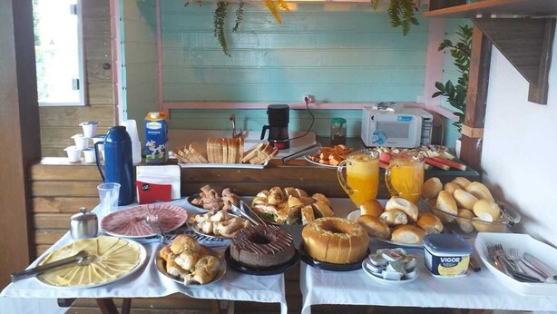 A breakfast buffet with various food items, a coffee machine, and a microwave. - Pousada Sonho Meu - Penha (Penha)