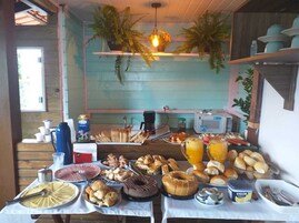 Um buffet de café da manhã com diversos alimentos, uma máquina de café e um micro-ondas.