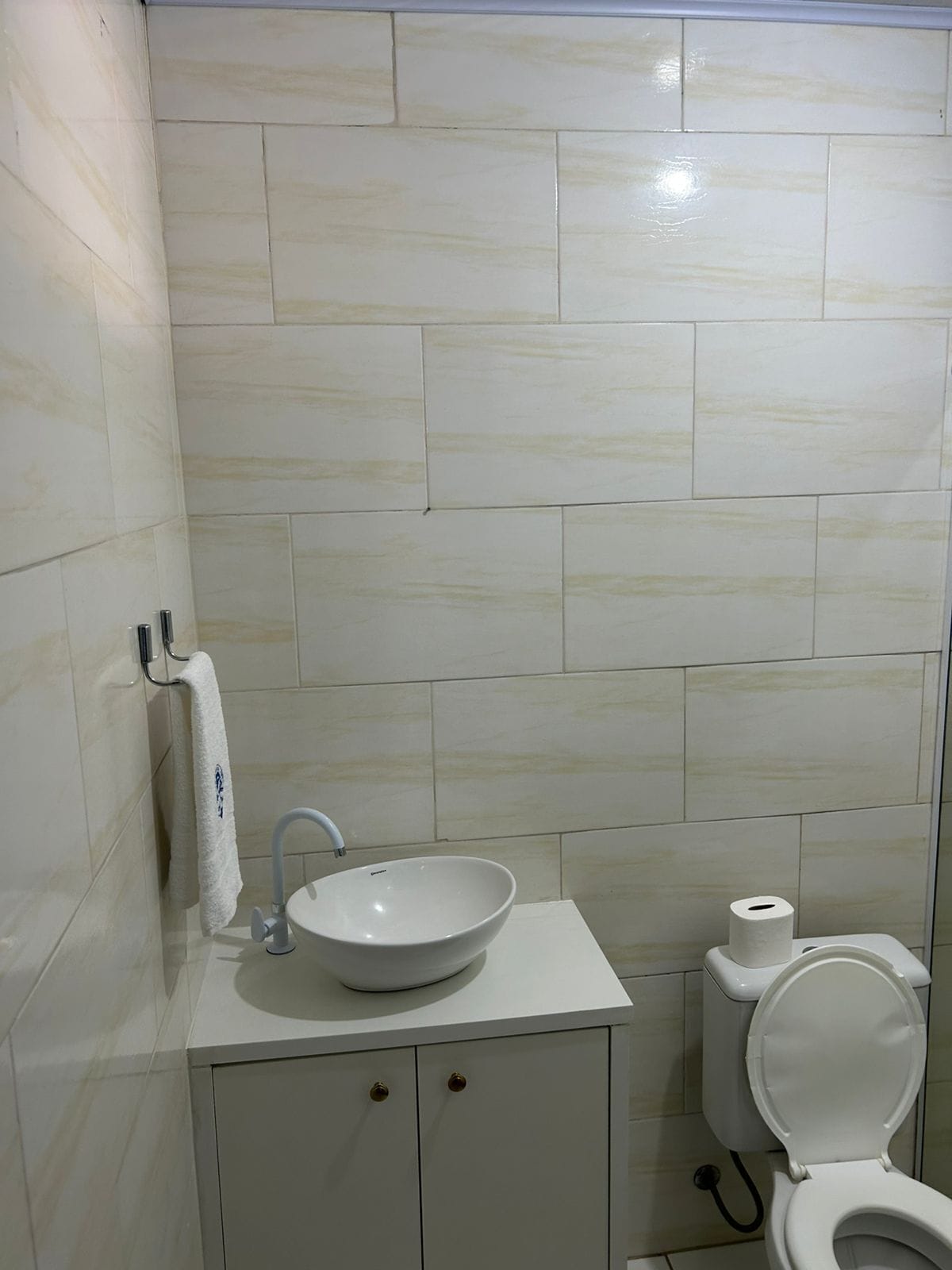 Un baño con lavamanos, inodoro y mueble blanco.