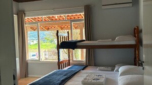 A room with a bunk bed, a window with curtains, a ceiling fan, and an air conditioning unit. - Pousada Sonho Meu - Penha (Penha)
