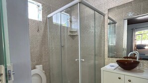 A bathroom with a glass shower enclosure, a toilet, a sink with a large bowl, and a mirror above the sink. - Pousada Sonho Meu - Penha (Penha)