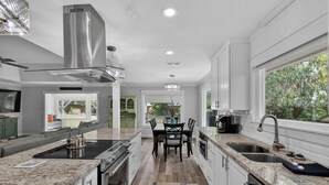 A modern kitchen with granite countertops, stainless steel appliances, and a central island.