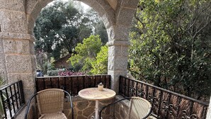 An outdoor patio with stone arches, wicker chairs, a round table, and a fire pit. - Forest retreat, close to Barcelona and Beaches (Dosrius)