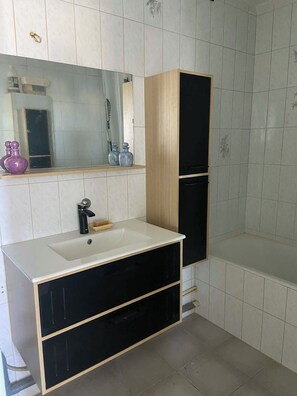 A bathroom with a white sink, black cabinets, and a mirror above it. - Magnificent apartment in a private residence for 8 people, 5 minutes from Lyon, view of Part Dieu (Bron)