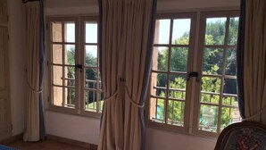 A room with large windows, a bed, and a chair. - Lovely family villa in Saint Paul de Vence (La Colle-sur-Loup)