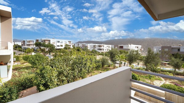A residential area with modern buildings, a clear sky, and a mountainous backdrop. - Cozy Stay in Modern Apt / Clean Comfortable & Calm (Imi Ouaddar)