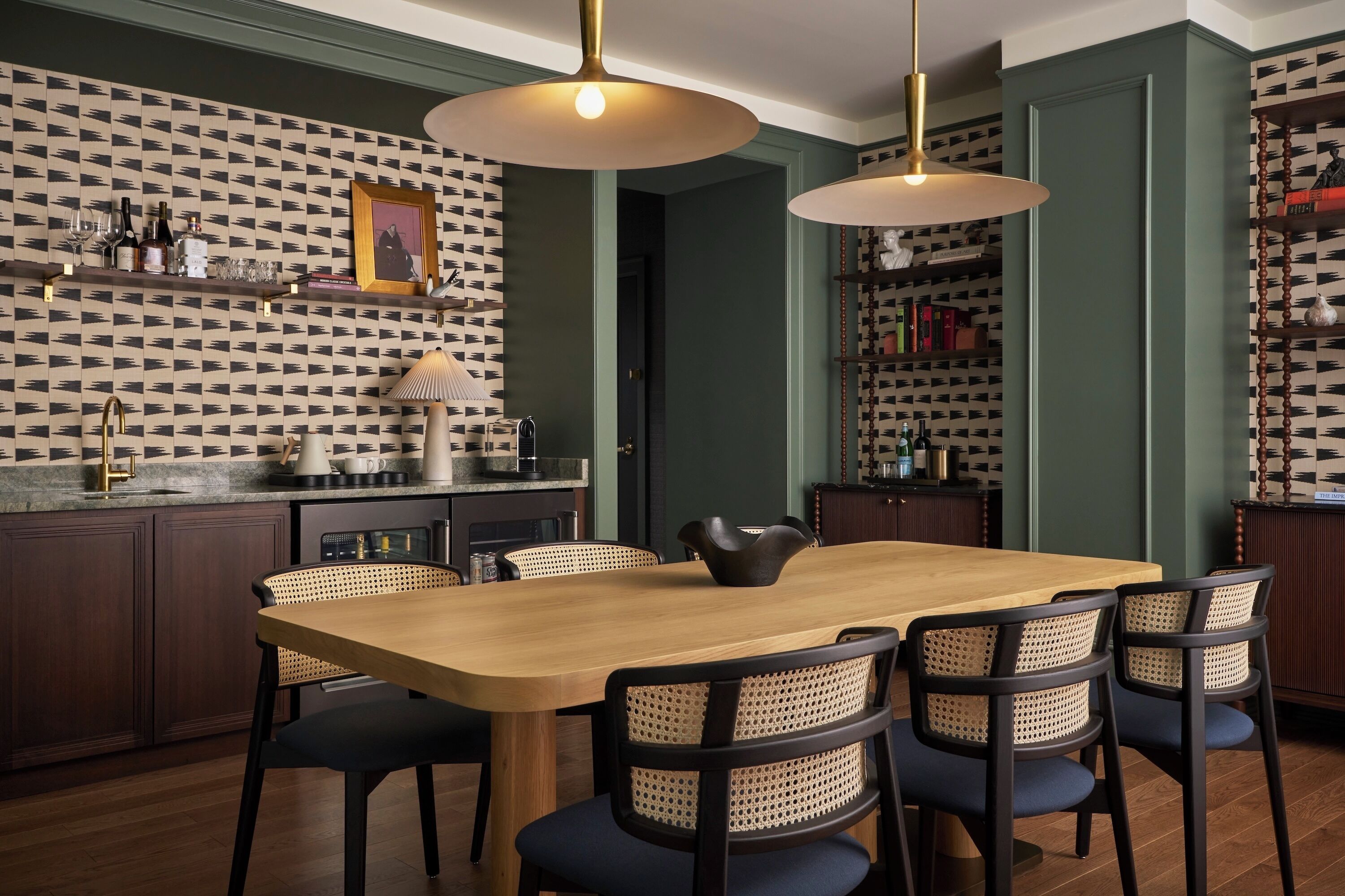 Uma sala de jantar com uma mesa de madeira, seis cadeiras e iluminação pendente.
