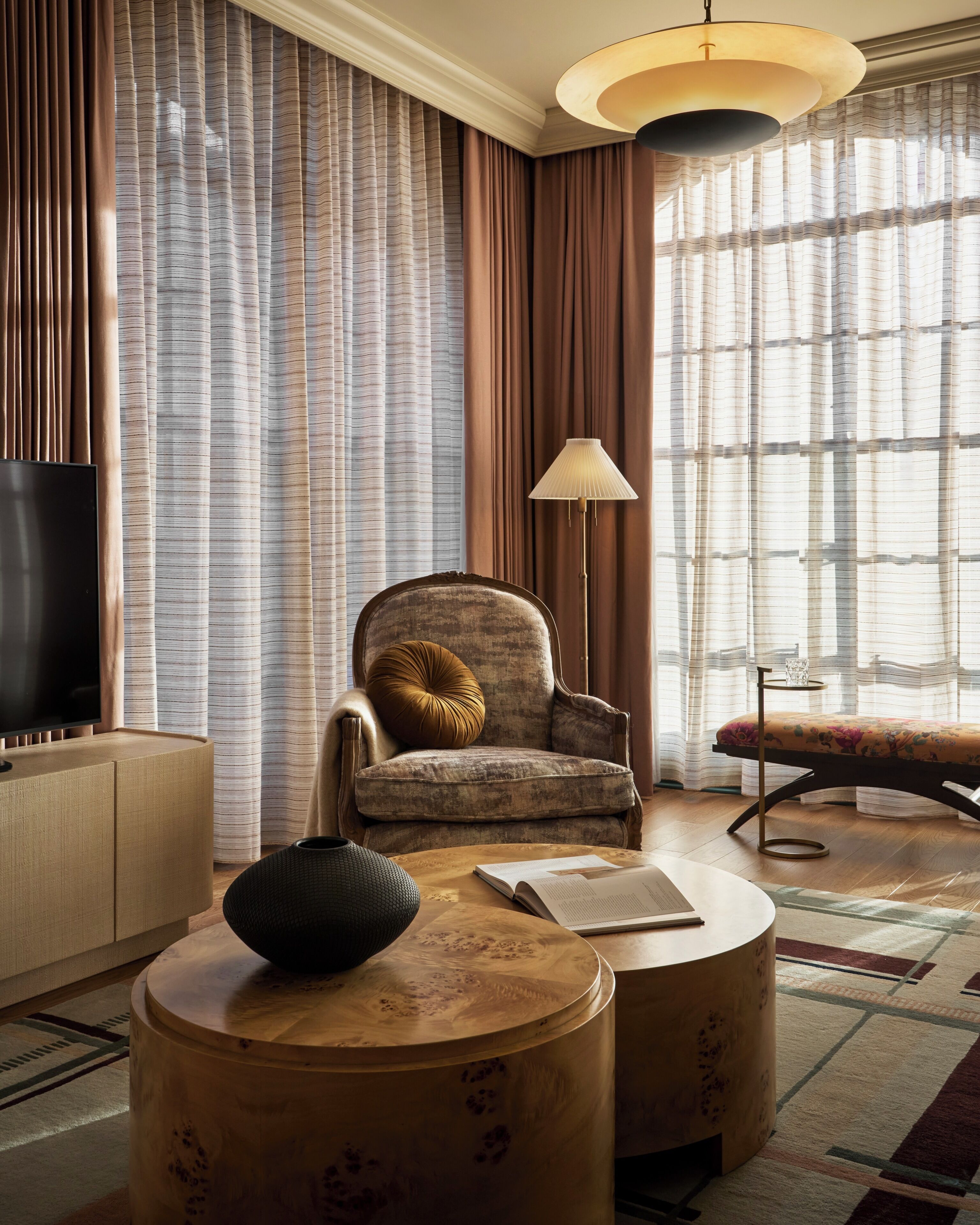 A modern living room with a sofa, armchair, and a TV.