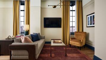 A living room with a sofa, armchair, coffee table, and a patterned rug.