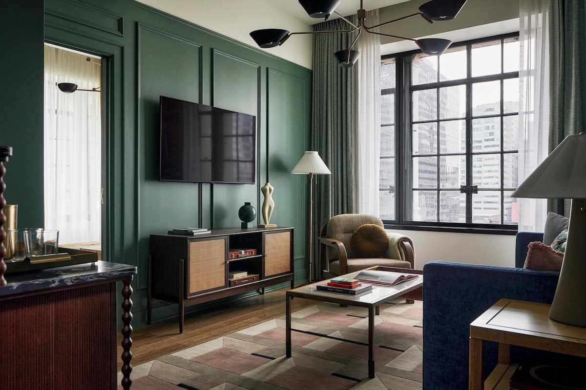 A living room with a television, a sofa, a coffee table, and a bookshelf.