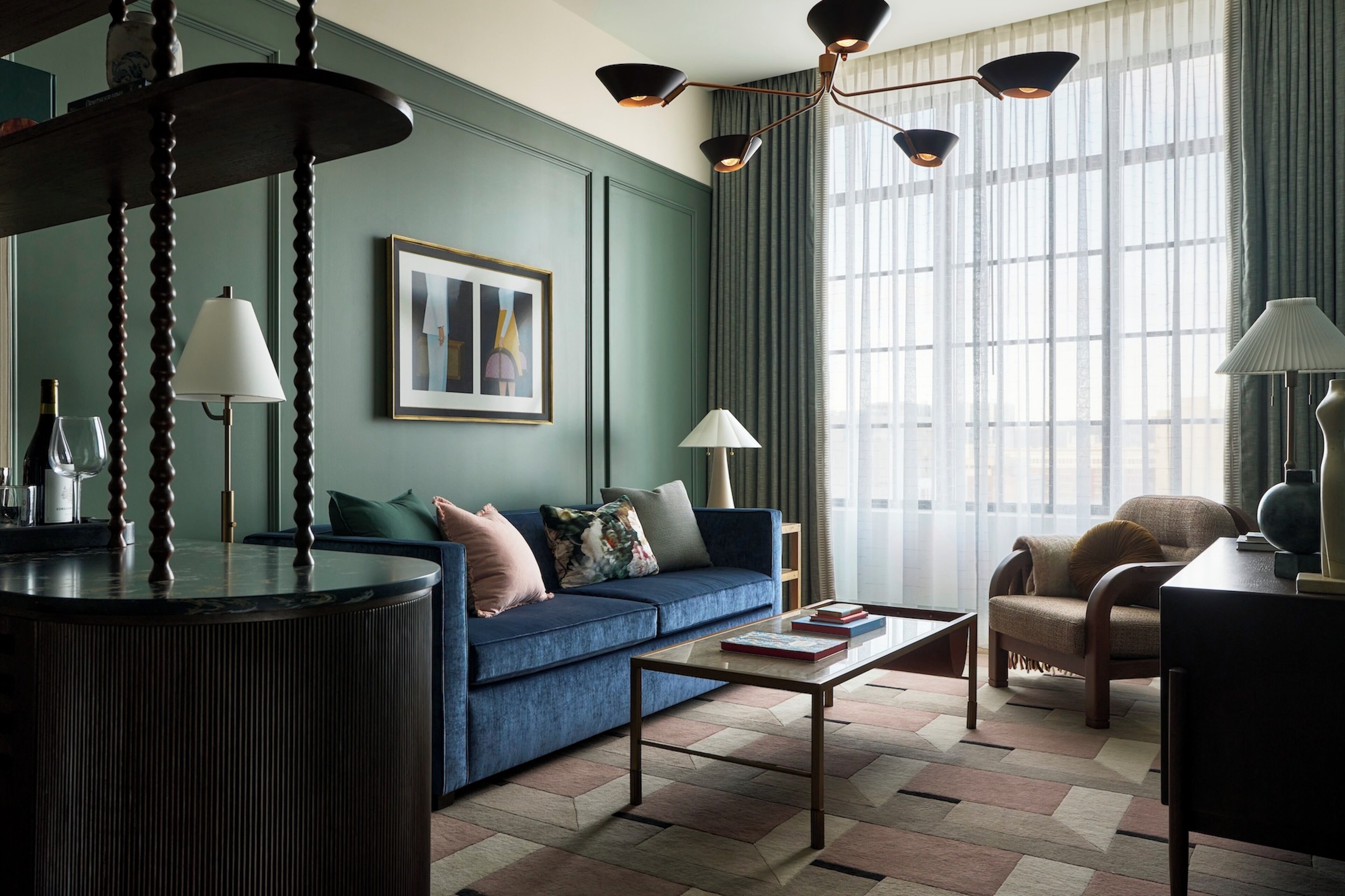 A modern living room with a blue sofa, a coffee table, and a lamp.