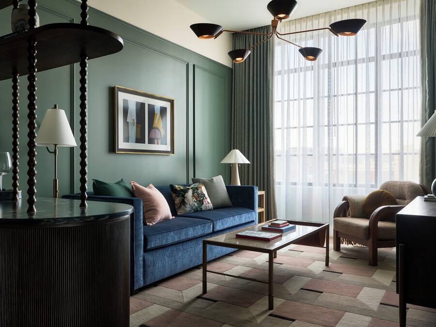 Ein modernes Wohnzimmer mit einem blauen Sofa, einem Couchtisch und einer Lampe.