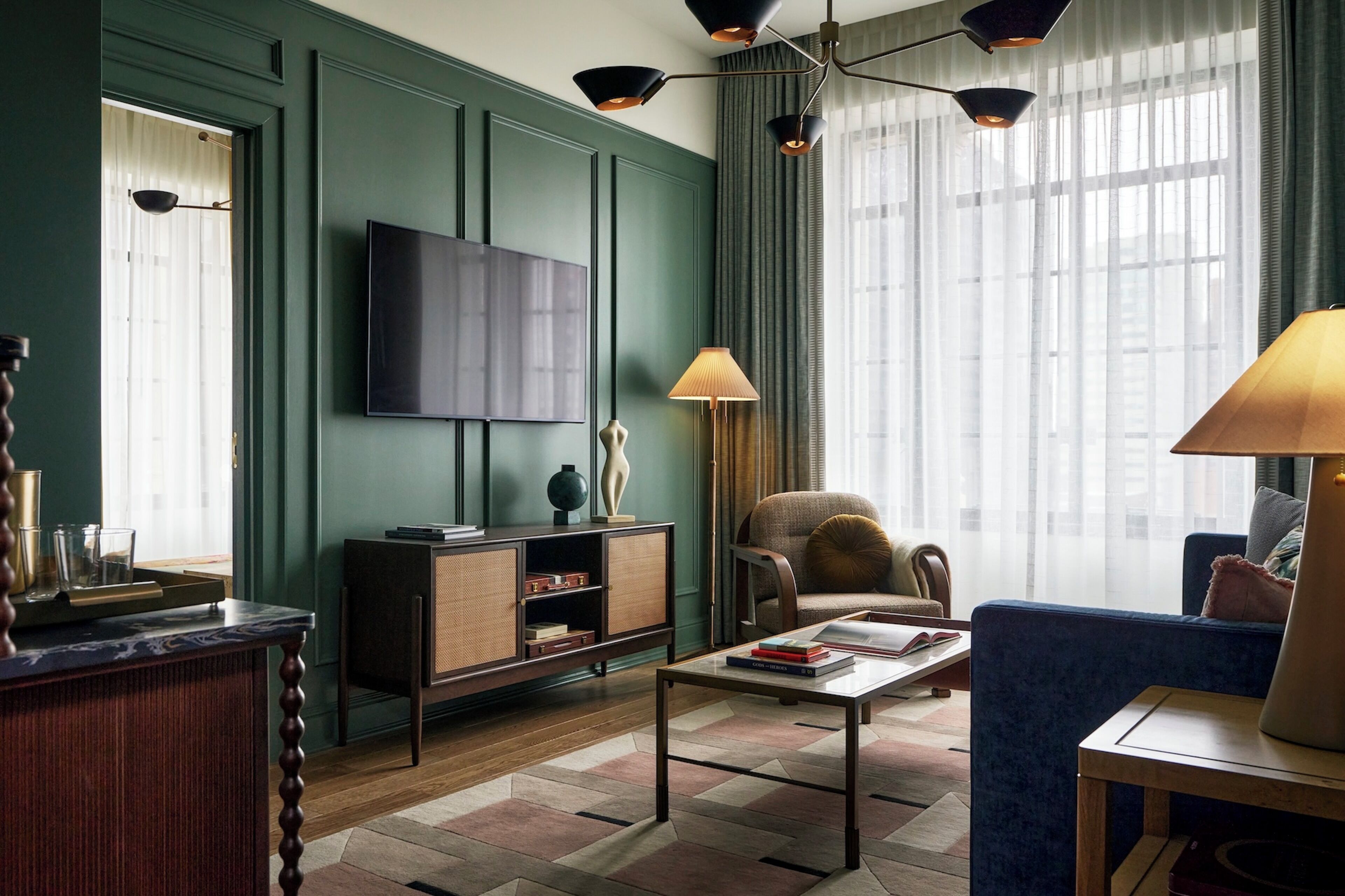 Een woonkamer met een televisie, een bank, een salontafel en een lamp.