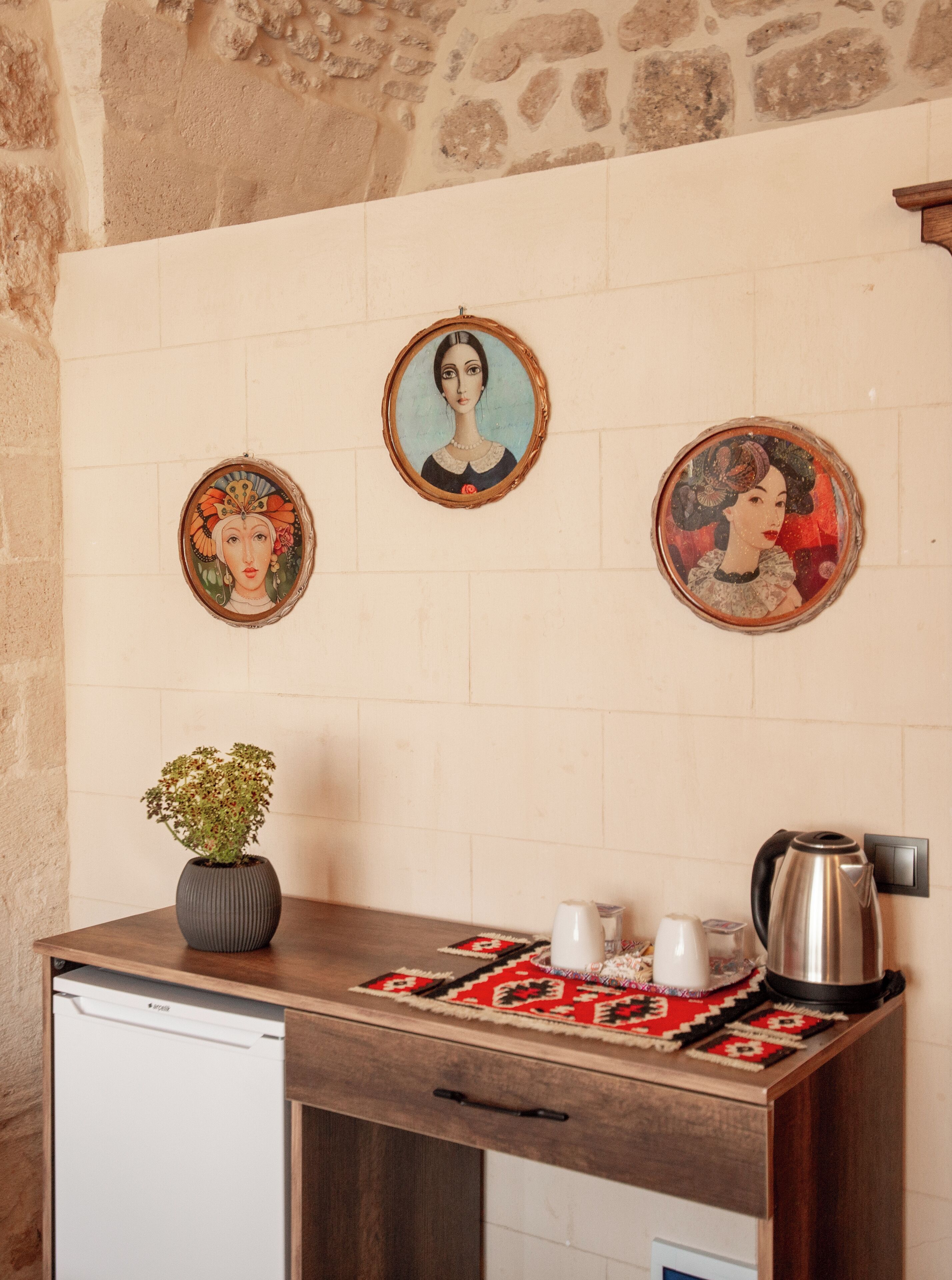A kitchen with a wooden counter, a coffee maker, and a potted plant.