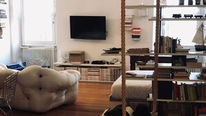 A living room with a swing, a television, bookshelves, and a radiator.