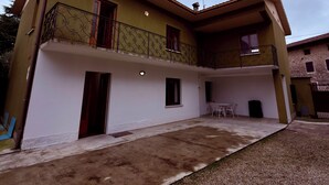 A two-story building with a balcony, a door, and a small outdoor seating area. - INDEPENDENT HOME FOR WORKERS AND FAMILIES in Orsaria (Orsaria)