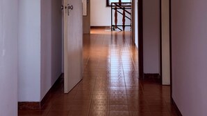 A hallway with a wooden floor, white walls, and a staircase leading to another room. - INDEPENDENT HOME FOR WORKERS AND FAMILIES in Orsaria (Orsaria)