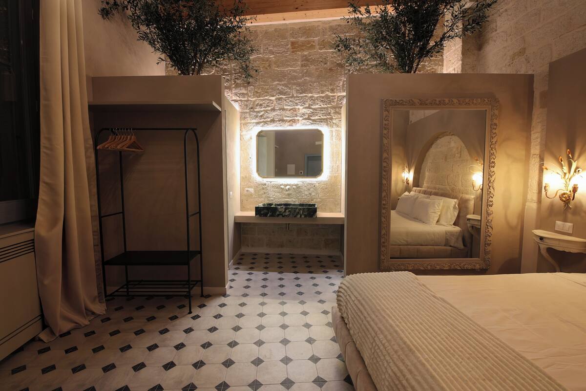 Une chambre à coucher avec un lit, une armoire suspendue, un miroir et une petite fenêtre.