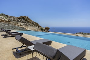 Area piscina con lettini e vista mare.