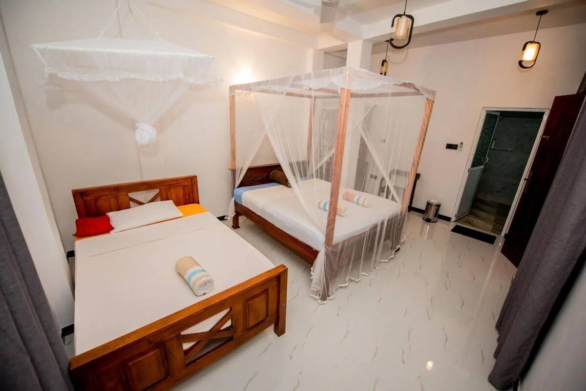 A bedroom with a wooden bed, a canopy bed, and a bedside table.