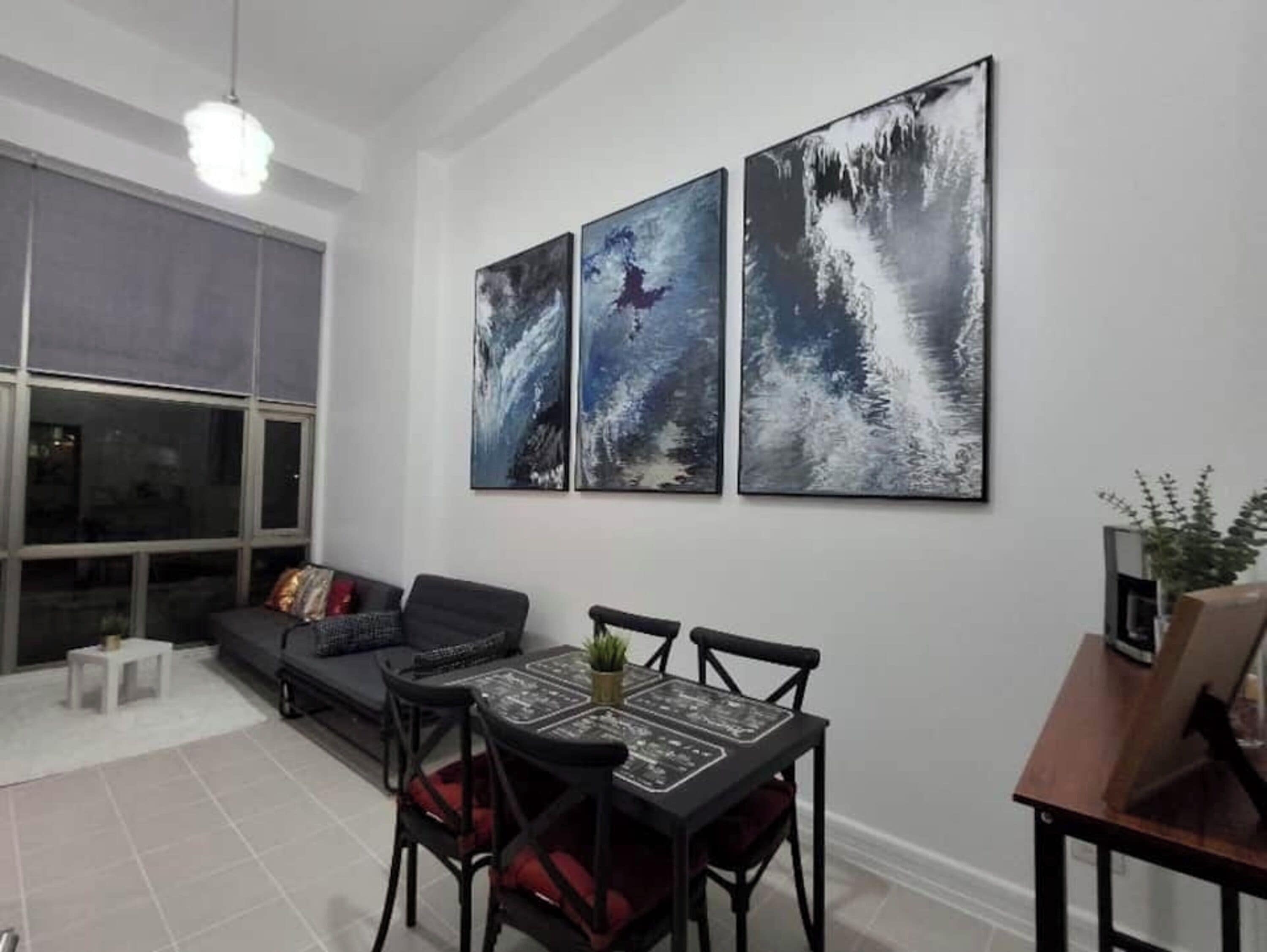 A dining area with a table, chairs, a sofa, and a large window.