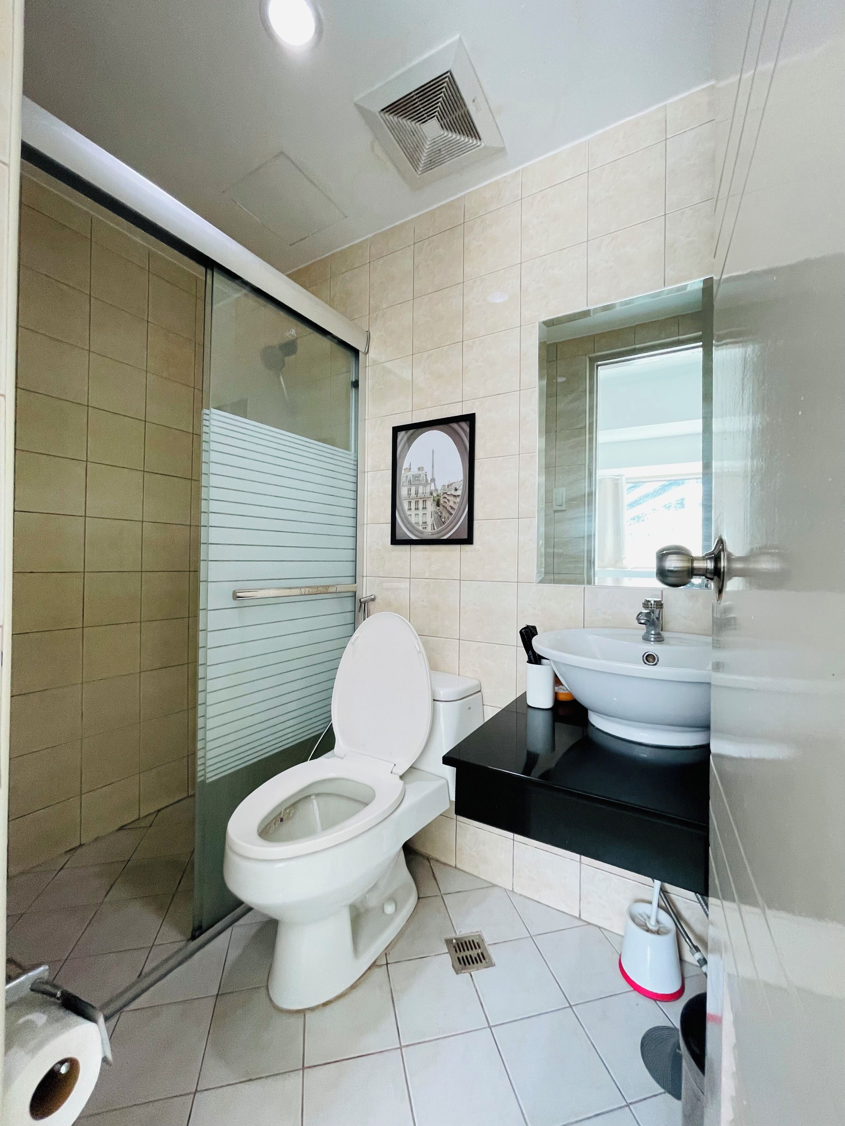 Une salle de bain moderne équipée de toilettes, d’un lavabo et d’une zone douche.