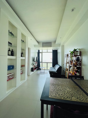 A modern living room with a sofa, a coffee table, and a bookshelf.