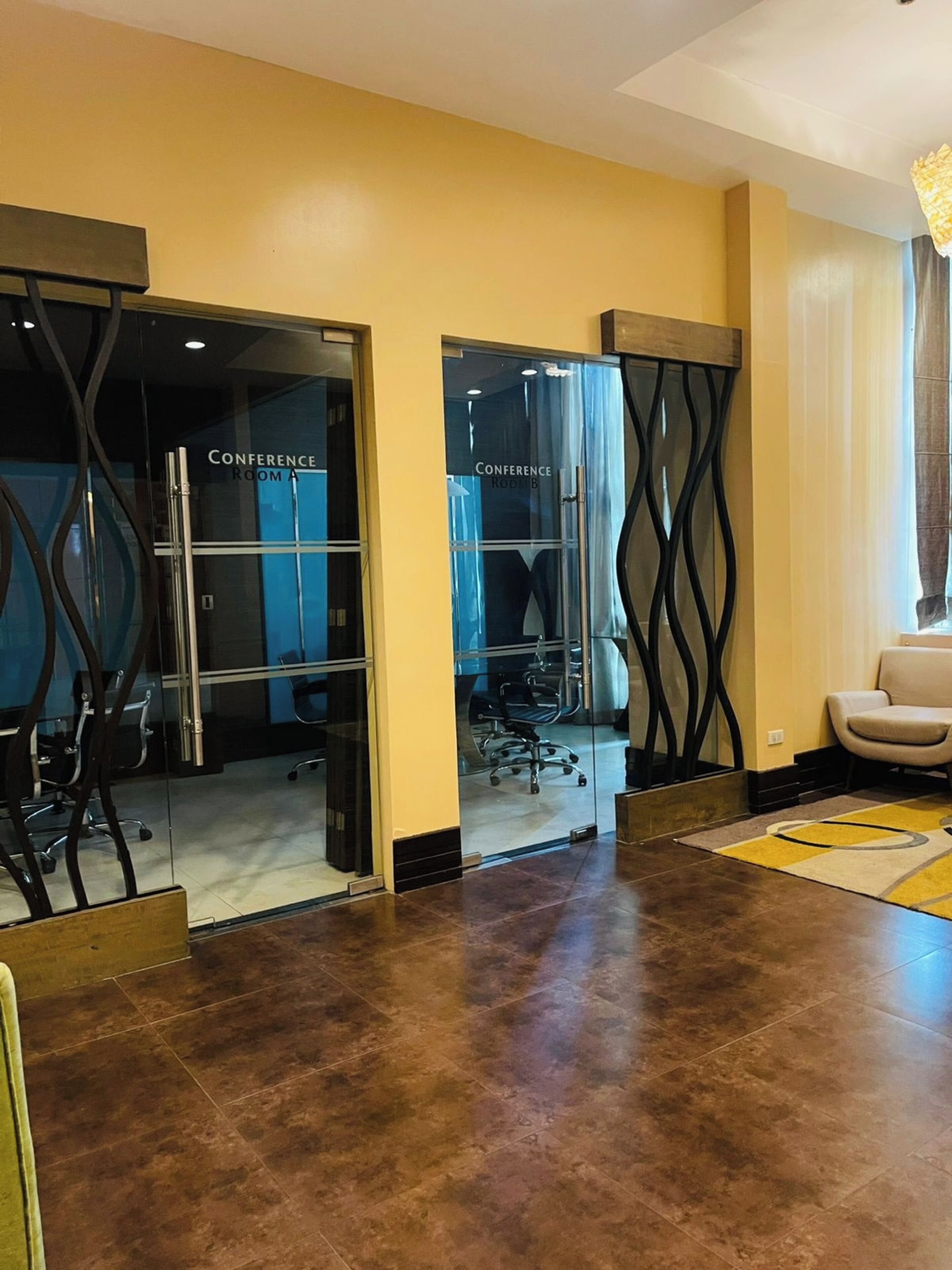 Un salón de conferencias con puertas de cristal, una silla y una alfombra.