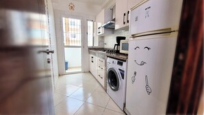 Cozinha equipada com máquina de lavar, micro-ondas e frigorífico.