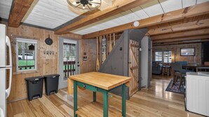Un interno in legno con angolo cottura, tavolo da pranzo e una scala.