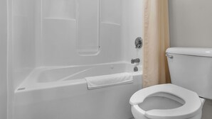 Un baño con bañera, inodoro y cortina de ducha.