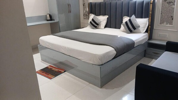 A modern bedroom with a bed, bedside tables, and a wardrobe. - Hotel Bella Casa (Purnia)