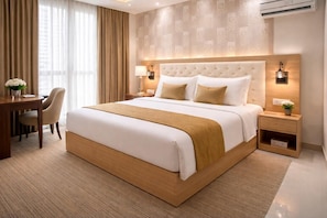 Una habitación de hotel con una cama grande, un escritorio y una silla.