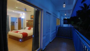 Un couloir d’hôtel avec un lit, un balcon et une vue sur l’extérieur.