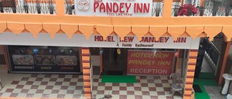 Un hotel llamado 'Hotel New Pandey Inn' con un letrero que indica que ofrece desayuno, almuerzo y cena.