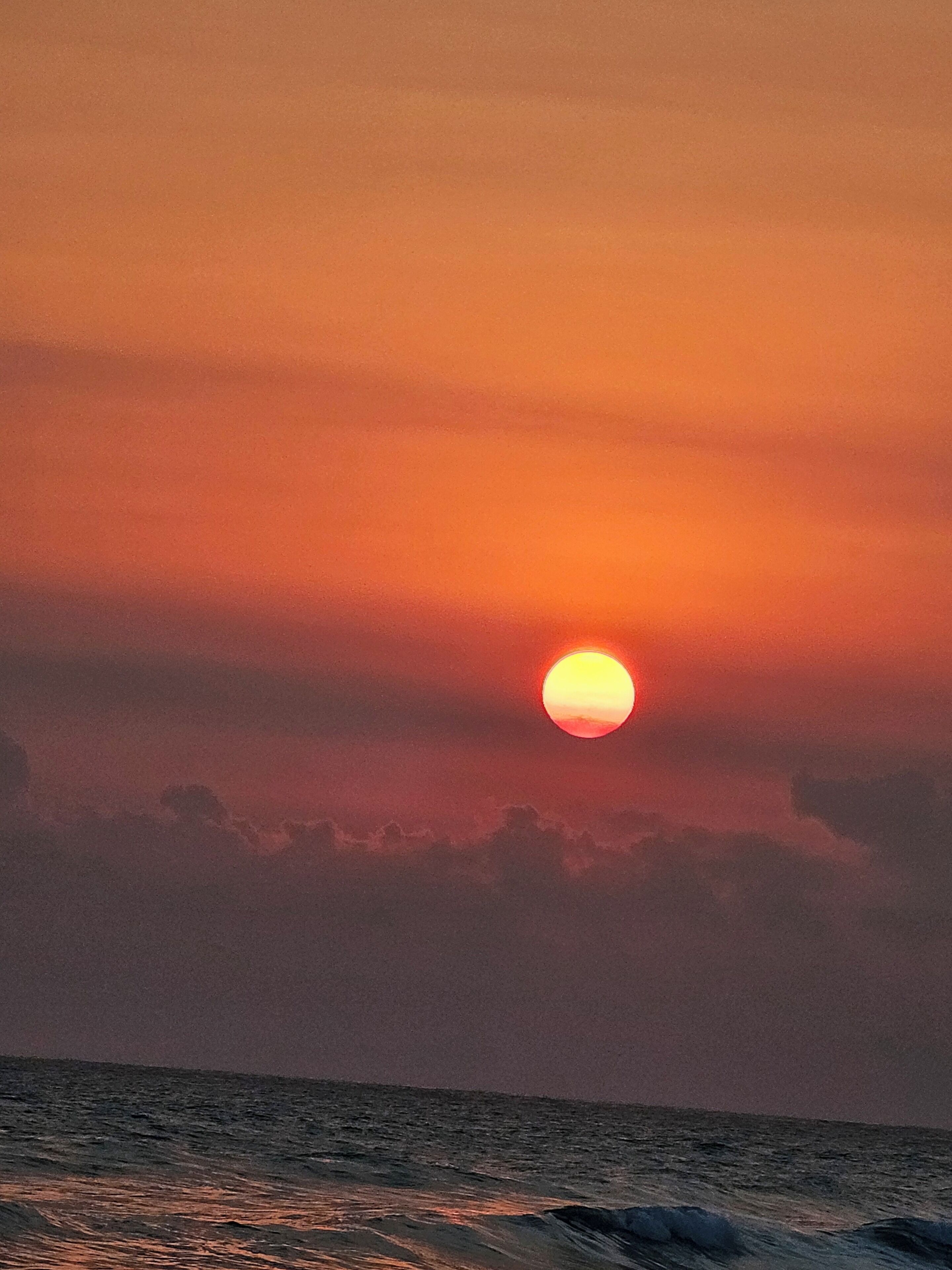 Solnedgang over havet med en klar himmel.