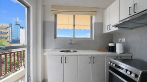 Eine moderne Küche mit Fenster, Spüle, Schränken und Herd.