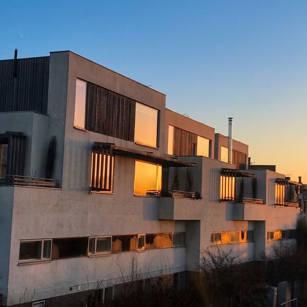 A modern multi-story building with large windows and balconies.